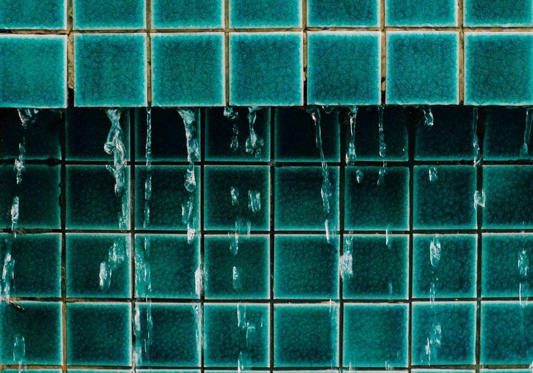Water running down tiled bathroom wall where mold grows in a Gettysburg PA home