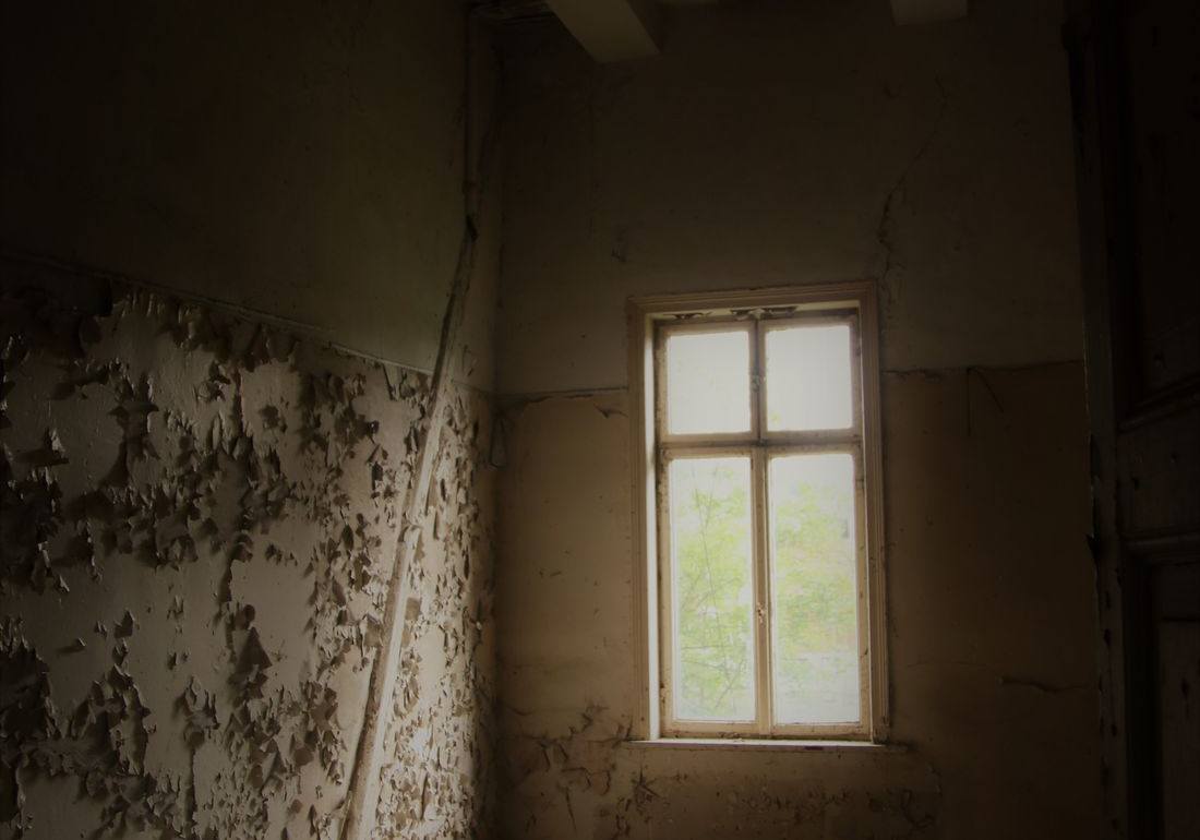 Old bathroom with water-stained, peeling walls where mold grows in an older rental property