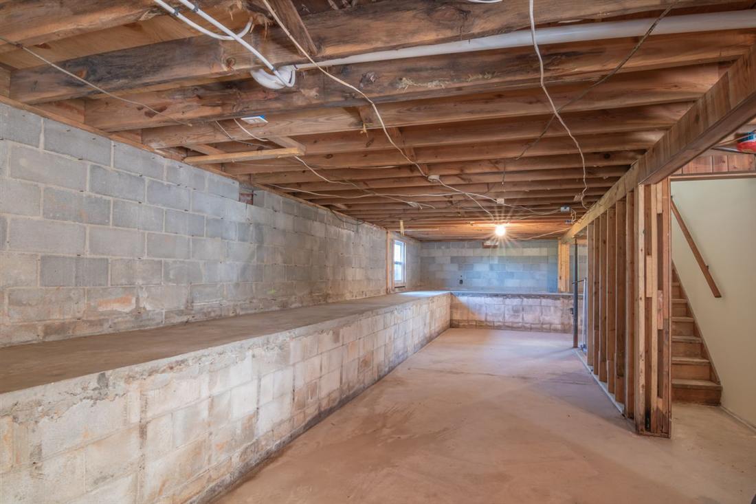 Unfinished basement with masonry walls and exposed floor joists like many older Gettysburg PA homes